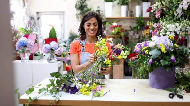 istock Happy florist creating some flower arrangements 2160584366