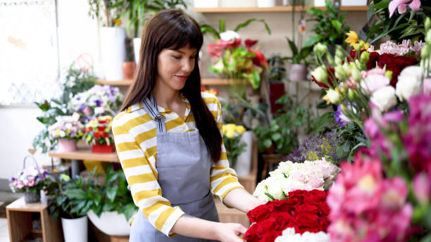 istock Happy florist enjoying arranging flowers 2160584493