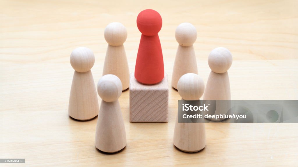 Leadership Concept with Wooden Figures This image illustrates a red wooden figure standing on a block, surrounded by natural wooden figures, symbolizing leadership and team dynamics. It represents themes such as leadership, direction, team discussion, community or social feedback, communication or announcement dialogue, business meetings, teamwork, and communication concepts. The clear and minimalist design makes it ideal for business presentations, educational materials, and articles related to leadership and organizational structures Chairperson Stock Photo Leadership Concept with Wooden Figures This image illustrates a red wooden figure standing on a block, surrounded by natural wooden figures, symbolizing leadership and team dynamics. It represents themes such as leadership, direction, team discussion, community or social feedback, communication or announcement dialogue, business meetings, teamwork, and communication concepts. The clear and minimalist design makes it ideal for business presentations, educational materials, and articles related to leadership and organizational structures Chairperson Stock Photo