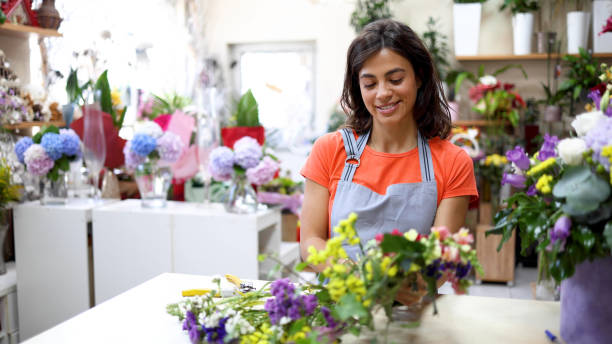 istock Happy florist creating some flower arrangements 2160585222