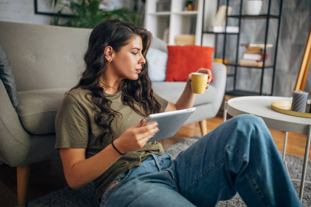istock Woman multitasks with coffee and tablet in cozy home 2160585973