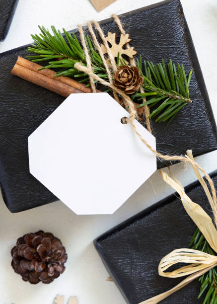 istock Black Christmas present with blank gift tag, decorated with fir branches, Mockup 2160586639