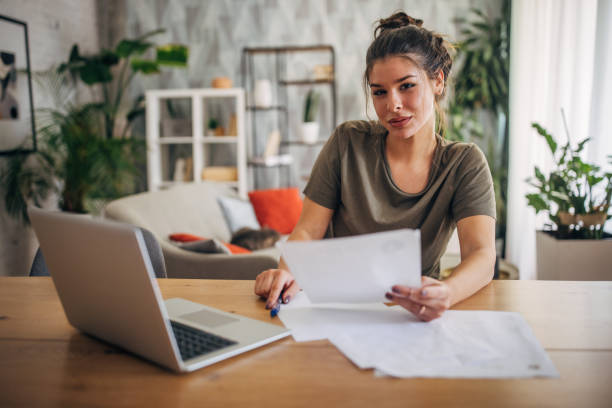 istock Focused woman checking paperwork at home office 2160589450