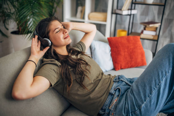istock Relaxed woman enjoying music on a comfy sofa 2160591173