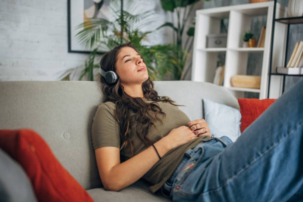 istock Relaxed woman enjoying music on a comfy sofa 2160591397