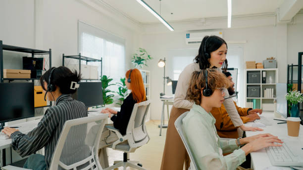 istock Asian customer care team working in their office with the supervisor overseeing the environment. 2160593073