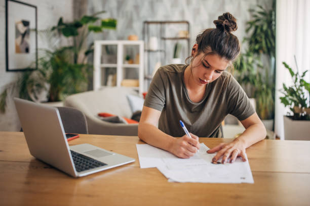 istock Woman engaged in writing at home workspace table. 2160593770