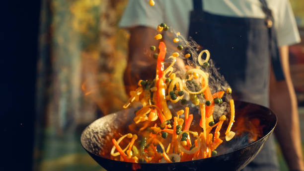 Chef Skillfully Tosses Vibrant Vegetables in Sizzling Wok, Capturing the Essence of Dynamic Cooking and Fresh Ingredients in Professional Kitchen Setting, Highlighting Culinary Expertise