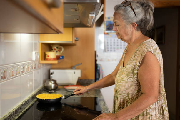istock Senior Woman Cooking Spanish Tortilla in Kitchen 2160594547