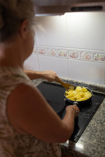 istock Senior Woman Cooking Potatoes in a Pan 2160594551