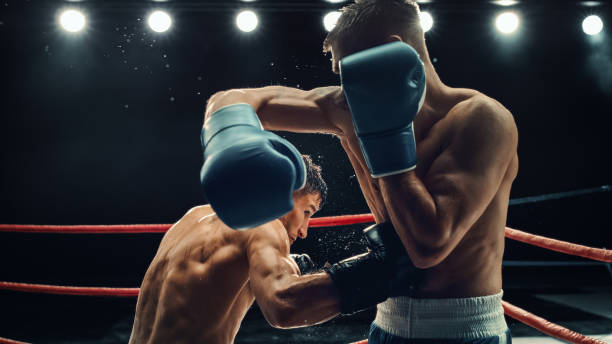 Two Male Boxers in High-stakes Match, Exchanging Powerful Blows Under Intense Lighting. Raw Energy and Fierce Competition at Boxing Championship, With Sweat Flying in Gripping Sports Moment