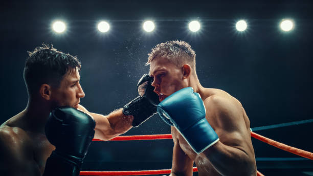 istock Intense Championship Boxing Match Between Two Male Fighters Under Bright Lights, Powerful Punches and Fierce Competition in the Ring. Sweat and Determination  in This High-energy Sports Moment. 2160594929