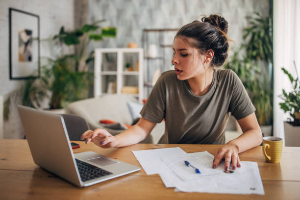 istock Woman working from home with laptop and documents. 2160595330