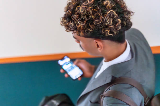 high angle view on young businessman with mobile phone walking down staircase