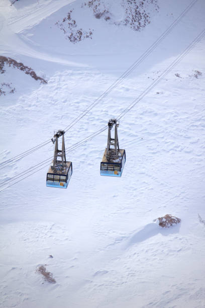 Aerial view of a chairlift and shadows on an empty ski slope, South Tyrol, Italy