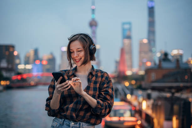 istock Smiling woman interacts with mobile phone by the water. 2160597544
