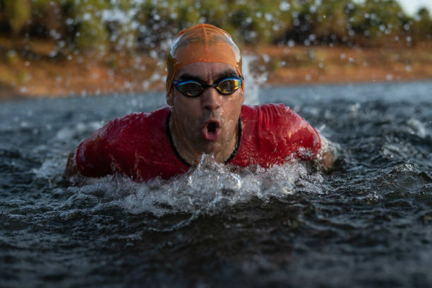 istock triathlete trains on a lake for competitions with his sunglasses and hat 2160597584