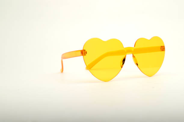 yellow heart-shaped sunglasses on clear background