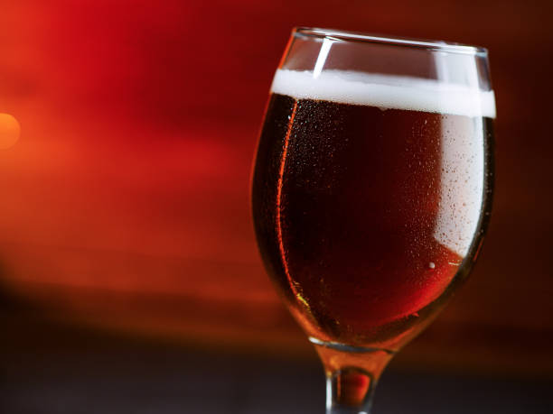 istock Beer glass on a red background. Amber Ale, copy space 2160598362
