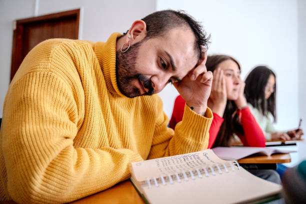 istock Mid adult man reading a notepad on language class in the classroom 2160598812