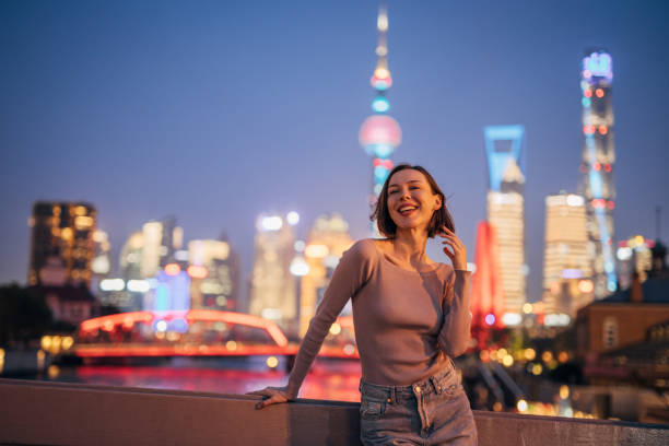 istock Woman posing by city railing at night with lights 2160599157