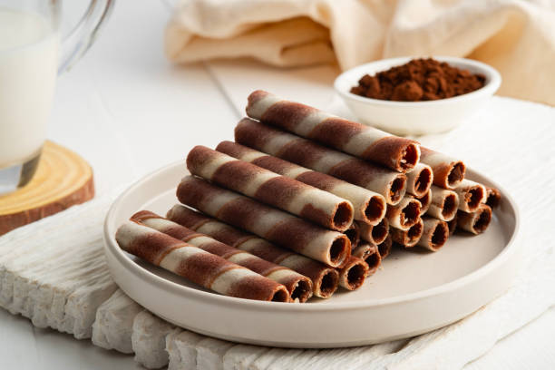 istock Chocolate cream flavour wafers sticks or wafer rolls in white plate. 2160599688