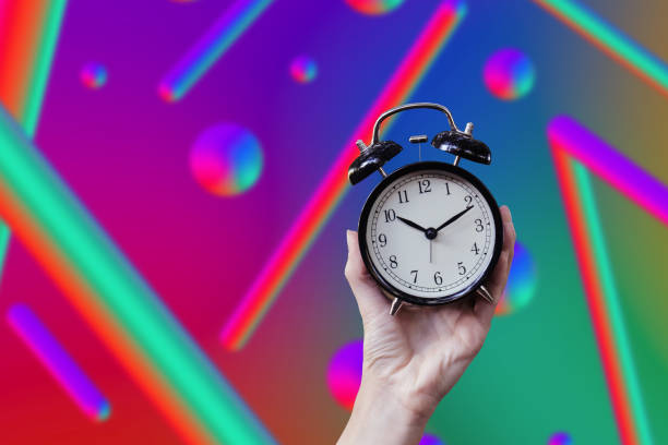 istock Woman holding alarm clock with neon light 2160606074