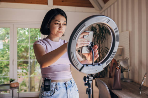 istock Woman setting up camera phone in modern home studio 2160607008