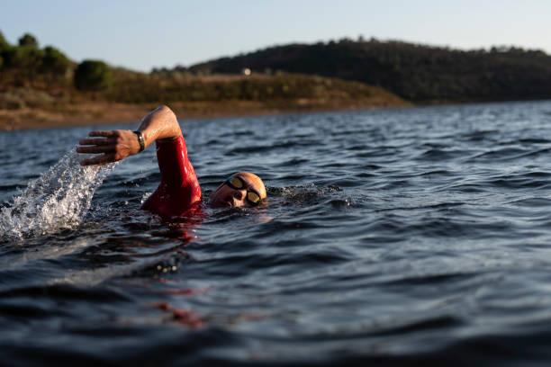 istock triathlete trains on a lake for competitions with his sunglasses and hat 2160607451