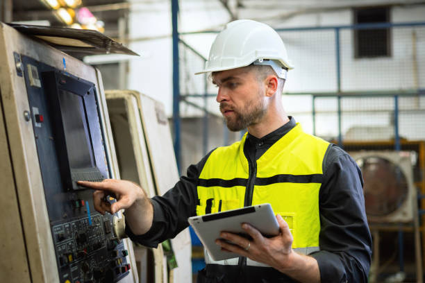istock man in a yellow vest is working on a machine with a tablet in his hand 2160607790