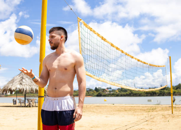 Beach volleyball player receiving the ball, action shot