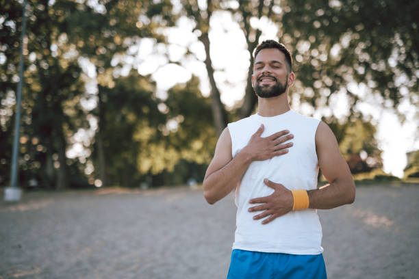 Man on beach feeling peaceful with hand on chest