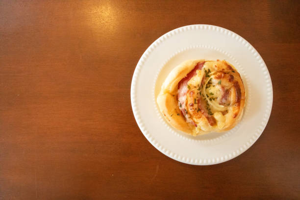 Freshly baked ham and cheese bread ready to eat on a white plate.