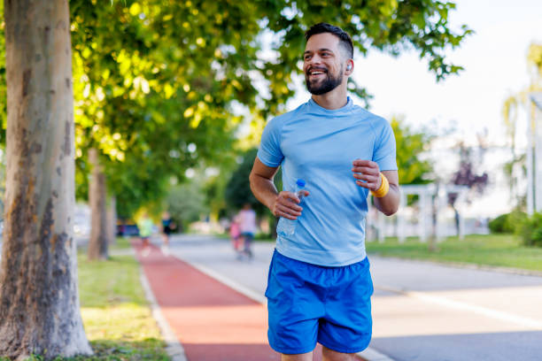 istock Man jogging with smiles in summer green park. 2160609852