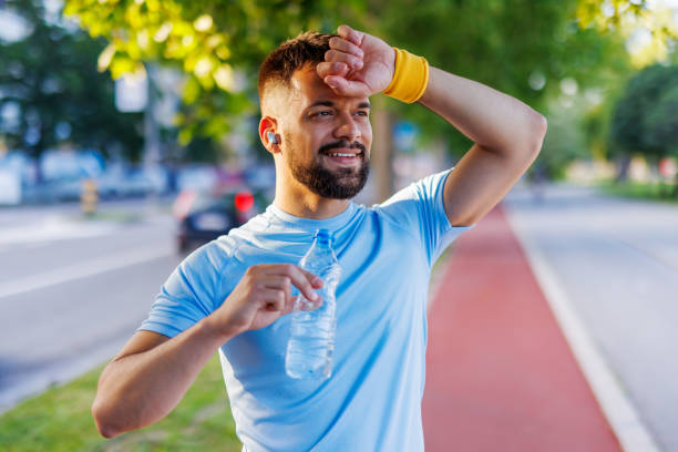istock Man cooling off with water bottle during morning workout 2160609945