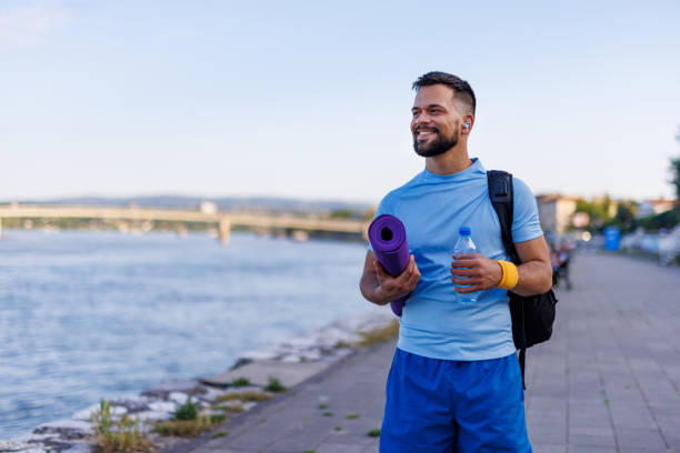 Man with yoga mat and water bottle ready for workout