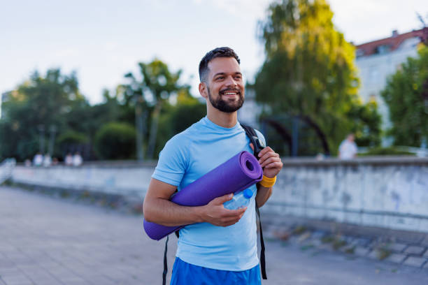 istock Smiling person holding yoga mat ready for workout 2160610028