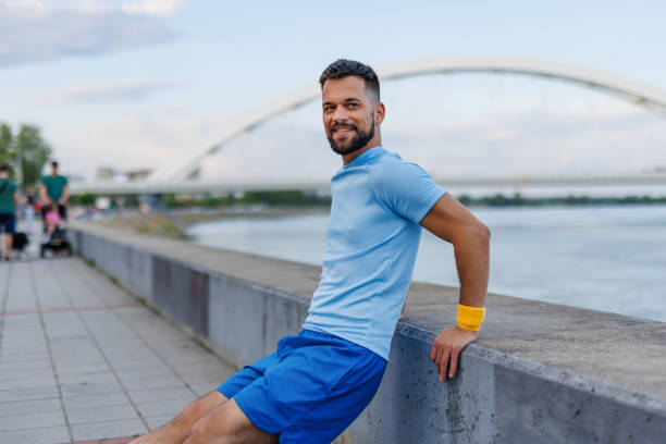istock Man smiling after workout sitting by the riverside 2160610354