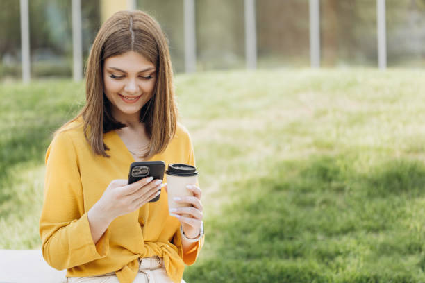istock Happy businesswoman using mobile phone at remote workplace. Smiling woman browsing internet on smartphone near office. Portrait of business woman reading messages on cellphone 2160610367