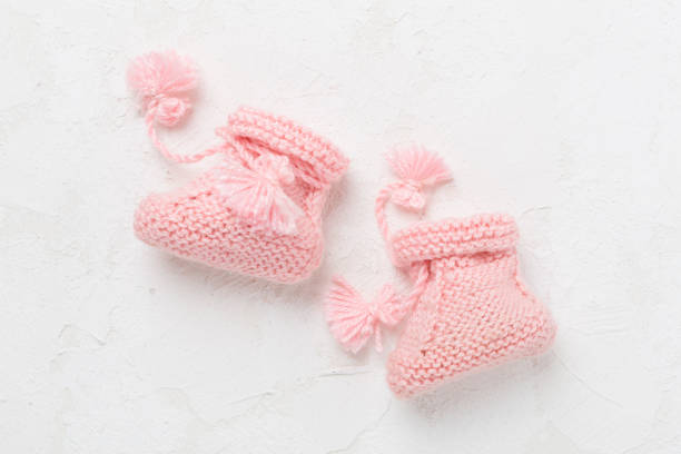 istock Pink baby booties on white background, top view 2160611456