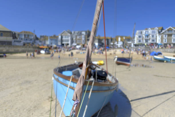 View across the harbour in the centre of St Ives Cornwall.  Boats can be seen moored and people can be seen on the promenade