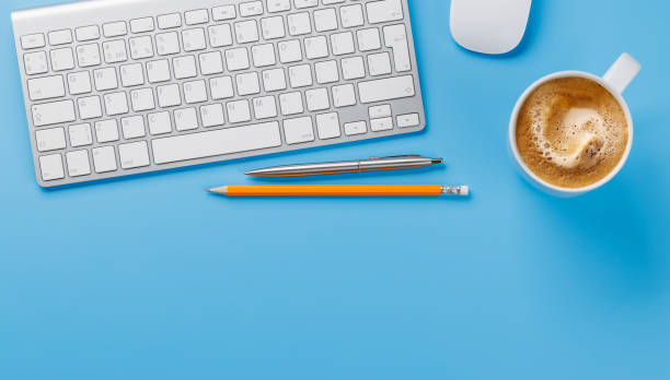 Office desk table with computer, cup of coffee and supplies. Top view with copy space. Flat lay