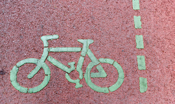 Bicycle lane sign on red asphalt road.