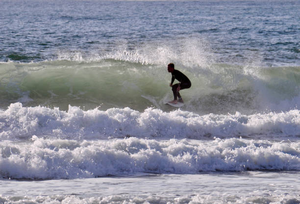 istock Surfer Glides across a Gray Green Wave 2160615005
