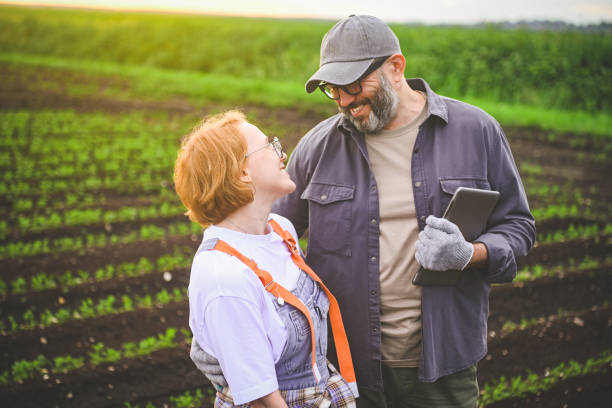 istock man and woman farmers checking vegetable field progress, holding tablet using internet. 2160616502
