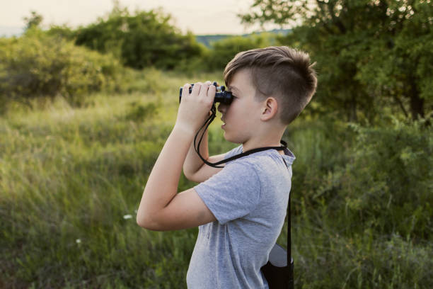 istock Boy is spending summer break with his grandfather on mountain. He is exploring nature with binoculars. 2160617720