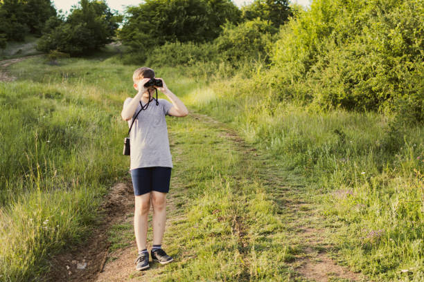 istock Boy is spending summer break with his grandfather on mountain. He is exploring nature with binoculars. 2160617794