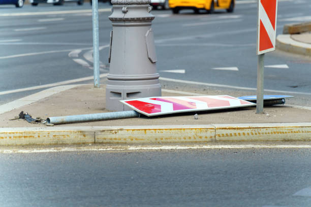 Broken road sign lying on the road, symbolizing traffic disruption, danger, and need for maintenance