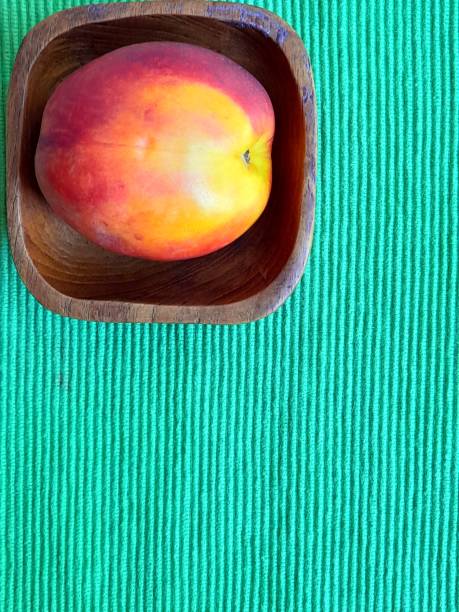 Nectarine in wooden plate