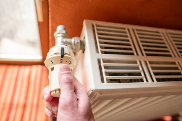 istock man adjusts radiator thermostat, controlling one's indoor environment and achieving personal comfort, saving heat, heating season, Creating cozy haven 2160627462